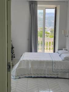 een slaapkamer met een bed en een groot raam bij Casa Torre a Sorrento con parcheggio gratuito in Sorrento