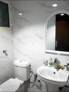 فندق اسكان وافر متوفر توصيل مجاني للحرم على مدار 24 ساعة في مكة المكرمة: حمام ابيض مع مرحاض ومغسلة