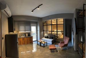 Una cocina y una sala de estar con un sofá y una mesa. en SALOMI LUXURY SUITES, en Ioannina