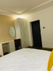 a bedroom with a large white bed and a black door at Iyoba Apartment in Abuja