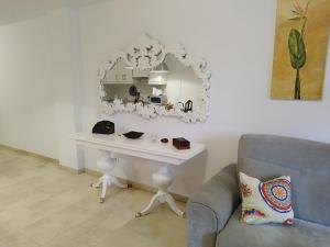 einen weißen Tisch mit einem Spiegel und einem Stuhl in der Unterkunft MAND CANTERAS in Las Palmas de Gran Canaria