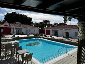 Paradise Resort - FKK Swinger & Nudist Couples Only في ماسبالوماس: مسبح كبير مع كراسي وطاولة