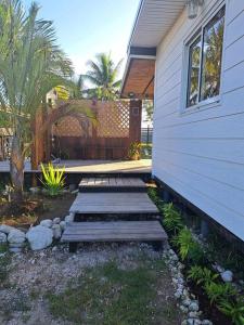 a backyard with a wooden walkway next to a house at Breeze Ocean Bungalow Moorea in Moorea