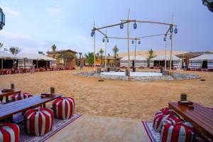een strand met rode en witte suikerstokken op banken bij Al Khayma Camp "Elite Camping & Dining in Experience" in Hunaywah