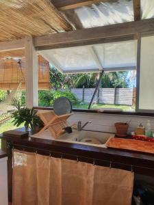 a kitchen with a sink and a window at Breeze Ocean Bungalow Moorea in Moorea