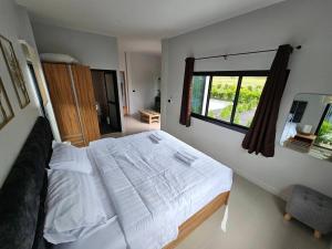 een slaapkamer met een groot bed en een raam bij The Hill Resort Thalang Phuket in Ban Chin Tham Mai