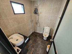 een kleine badkamer met een toilet en een wastafel bij The Hill Resort Thalang Phuket in Ban Chin Tham Mai