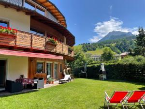 una casa con cortile, sedie e balcone di Villa Anita San Vigilio di Marebbe a San Vigilio Di Marebbe