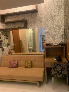 a living room with a couch and a mirror at Apartmen 1BR di Surabaya timur in Surabaya
