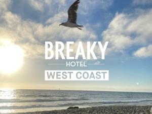 un pájaro volando sobre la playa con las palabras Breakley hotel costa oeste en BREAKY HOTEL west coast en Urazoe