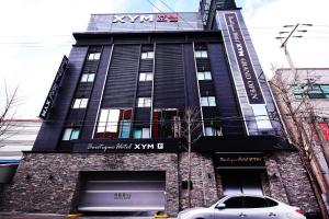 a building with a car parked in front of it at XYM Hotel Mundeok in Pohang