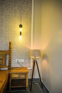 a lamp and a table in a room with a wall at The Arham Resort in Udaipur