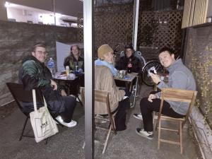 un grupo de personas sentadas en mesas en un restaurante en J's Backpackers, en Tokio