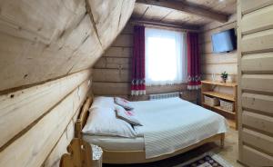 a small bedroom with a bed in a log cabin at Pokoje regionalne u Ani in Zakopane