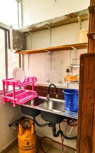 a kitchen with a sink and pink drying racks at Mount View Residencies in Colombo