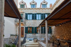 a building with green shutters and a patio at Hedera Estate, Villa Hedera XVII in Dubrovnik