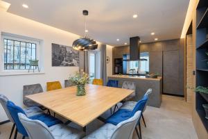 a dining room with a wooden table and blue chairs at Hedera Estate, Villa Hedera XVII in Dubrovnik