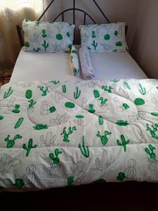a bed with a white comforter with green plants on it at Arusha homestay in Arusha