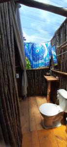 a bathroom with a toilet on a balcony at MALOCA - Chalés Rústicos in Ilha de Boipeba