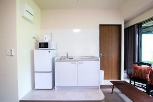 a kitchen with a white refrigerator and a sink at Arbor house in Kagoshima +18 photos