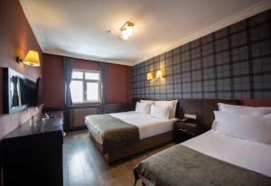 une chambre d'hôtel avec deux lits et une télévision dans l'établissement NO 21 HOTEL BY FİDAN HOCA, à Bursa