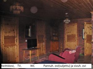 a living room with red chairs and a tv at Rinne in Rymättylä