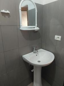 y baño con lavabo blanco y espejo. en Guest House Xhaferaj en Berat