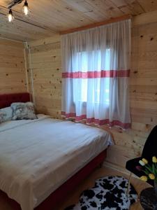 1 dormitorio con cama y ventana en Bungalovi Mihajlo & Miloš, en Tjentište
