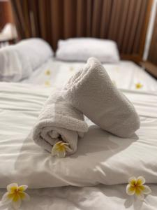 a towel on a bed with flowers on it at Kelingking Hostel in Klungkung