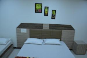 een slaapkamer met een groot bed met een blauw licht bij HOTEL SAIPRASAD LODGE Solapur in Solapur