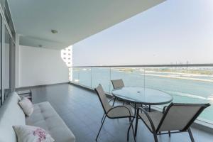 a living room with a couch and a table with chairs at Holiday Apartment in Palm Jumeirah with Beach Access in Dubai