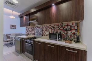 a kitchen with wooden cabinets and a stove top oven at Holiday Apartment in Palm Jumeirah with Beach Access in Dubai