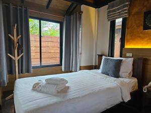 a bedroom with a large bed with towels on it at R1 Resort Rajapruek Chiangmai in Chiang Mai