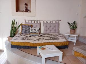 a bed with pillows and a table in a room at Bezari pool villa in Metochia Fratzeskiana