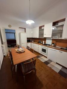 uma grande cozinha com uma mesa de madeira e cadeiras em Porta Venezia Apartament em Milão