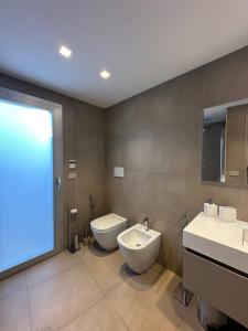 a bathroom with a toilet and a bidet and a sink at MP Luxury House in Budoni