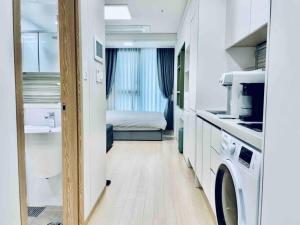a small room with a sink and a washing machine at NEST Myeongdong Residence high floor #Namsan #Hanok village #Gyeongbok palace #Euljiro in Seoul