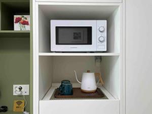 a microwave oven sitting on top of a shelf at NEST Myeongdong Residence high floor #Namsan #Hanok village #Gyeongbok palace #Euljiro in Seoul