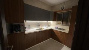 a kitchen with a sink and a microwave at شقة فندقية فاخرة بحي الروضة in Jeddah