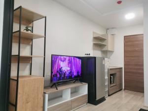 a living room with a flat screen tv on a shelf at Cozy room, BKK for short and long term rentals, 10mins walk to BTS, 25mins taxi to DMK airport in Ban Ko