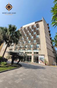 ein Gebäude mit einer Palme davor in der Unterkunft West Lake 254D Hotel & Residence in Hanoi