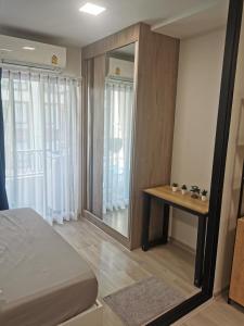 a bedroom with a bed and a large mirror at Cozy room, BKK for short and long term rentals, 10mins walk to BTS, 25mins taxi to DMK airport in Ban Ko