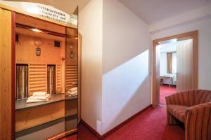 a room with a glass display case and a chair at Hotel Maria Theresia in Gerlos