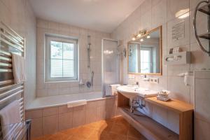 ein Badezimmer mit Badewanne, Waschbecken und Badewanne Tubermottermott in der Unterkunft Hotel Maria Theresia in Gerlos