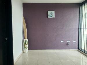 pasillo con paredes de color púrpura y suelo de baldosa en Casa Santa María en Pénjamo