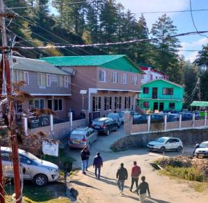 un grupo de personas caminando por una calle cerca de casas en Mountain view stay in Auli en Joshīmath