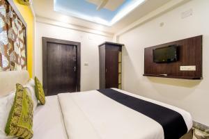 a bedroom with a bed and a tv on the wall at Puja Residency in Thākurdwari