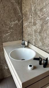 a white sink in a bathroom with a marble wall at Desert waves camp in Bidiyah
