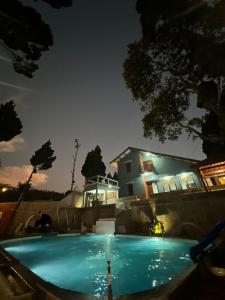 una piscina frente a una casa por la noche en Villa Kaki Bukit Ciwidey, en Cisondari