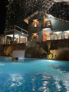 - une piscine en face d'une maison la nuit dans l'établissement Villa Kaki Bukit Ciwidey, à Cisondari
